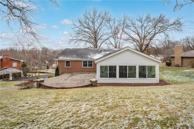 back of house with a patio, brick siding, and a lawn