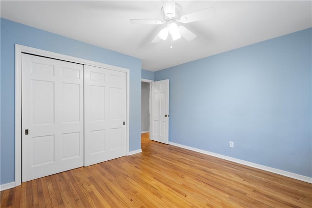 unfurnished bedroom with light wood-style floors, a ceiling fan, baseboards, and a closet