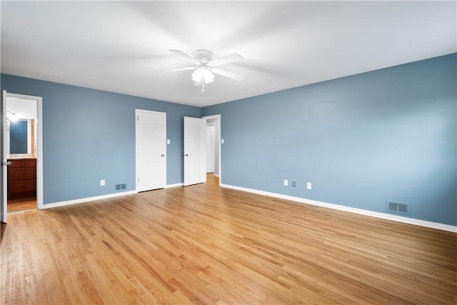 unfurnished bedroom with light wood-style floors, baseboards, visible vents, and ensuite bathroom