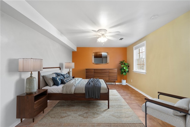 bedroom featuring a ceiling fan, light tile patterned flooring, visible vents, and baseboards