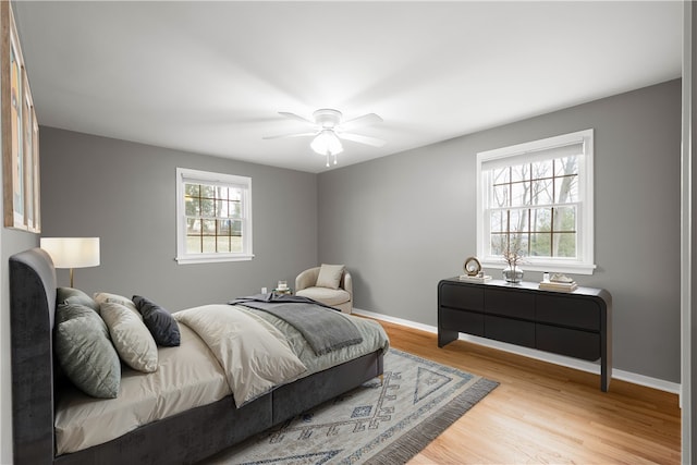 bedroom with ceiling fan, baseboards, and wood finished floors