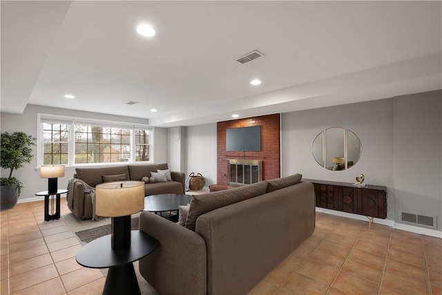 living room with a fireplace, visible vents, and light tile patterned flooring