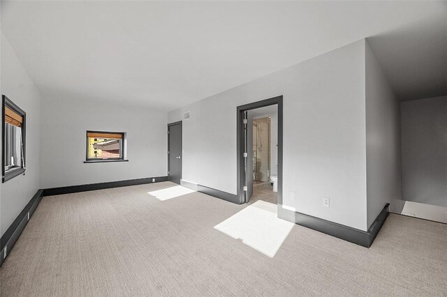 unfurnished room featuring light carpet, visible vents, and baseboards