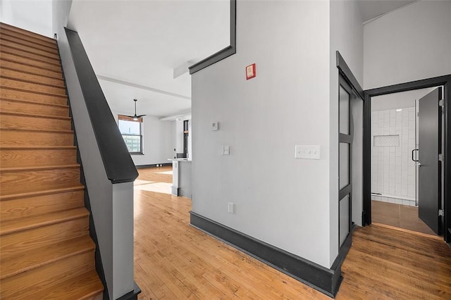 corridor featuring stairs and light wood-style floors