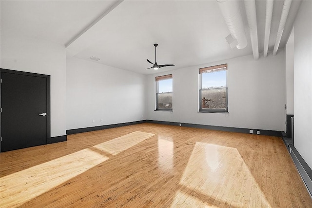 empty room featuring ceiling fan, wood-type flooring, visible vents, and baseboards