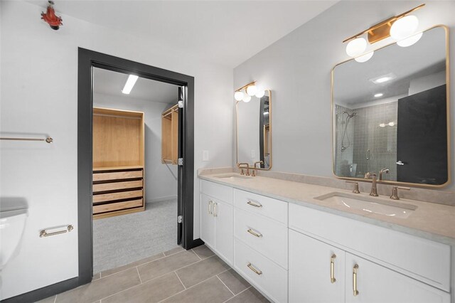 full bathroom with double vanity, a stall shower, a sink, and tile patterned floors