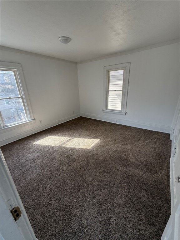 empty room featuring a wealth of natural light, carpet flooring, and baseboards