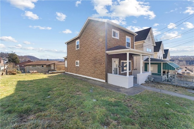 view of home's exterior featuring a yard, brick siding, fence, and a sunroom