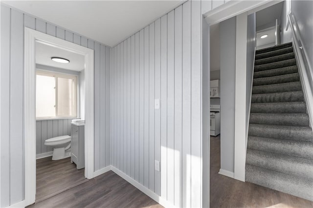 hall with stairs, dark wood-type flooring, and baseboards