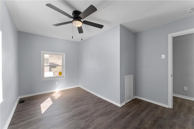 unfurnished room featuring ceiling fan, dark wood-type flooring, visible vents, and baseboards