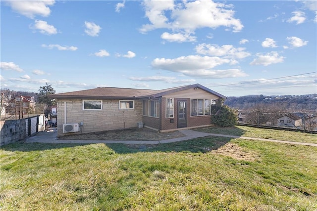 back of property featuring stone siding, fence, and a lawn