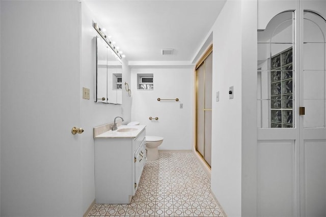 full bath featuring toilet, visible vents, vanity, a shower stall, and tile patterned floors