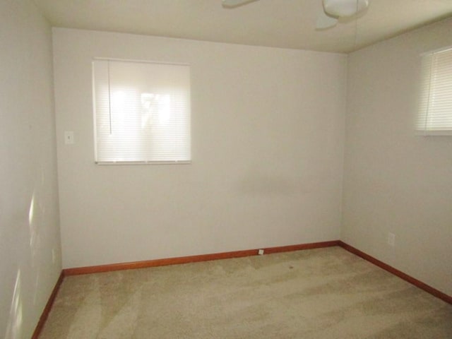 unfurnished room featuring baseboards, a ceiling fan, and light colored carpet