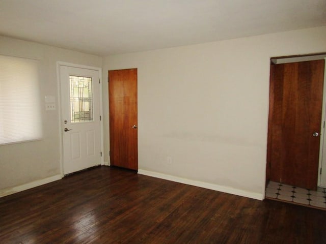 unfurnished room featuring baseboards and wood finished floors