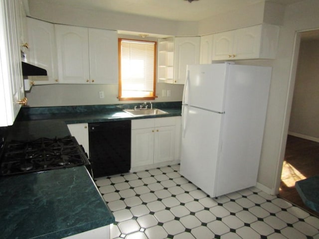 kitchen featuring dark countertops, freestanding refrigerator, a sink, gas range, and dishwasher