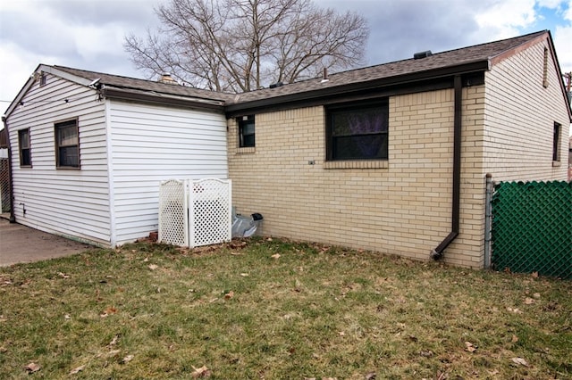 view of side of home featuring brick siding and a lawn