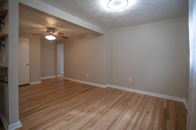 empty room with light wood-style floors, baseboards, and a ceiling fan