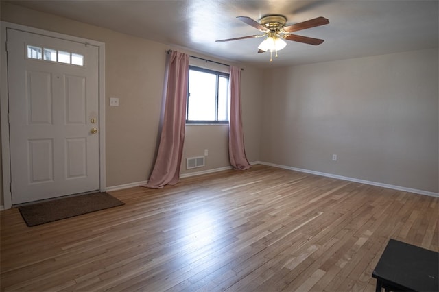 foyer with light wood-style floors, baseboards, and visible vents