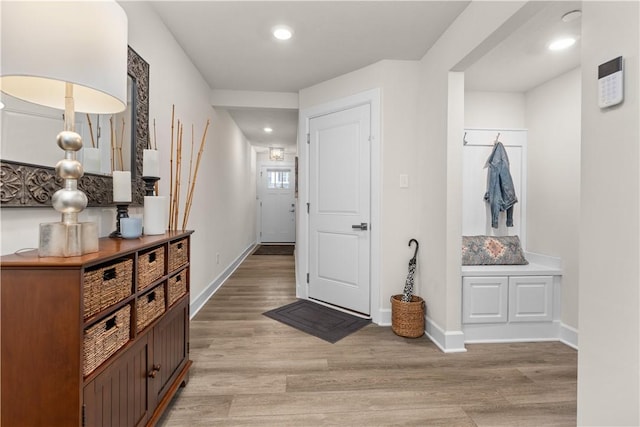 foyer with light wood-type flooring, baseboards, and recessed lighting