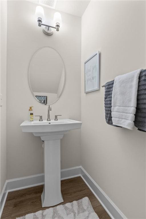 bathroom with wood finished floors and baseboards