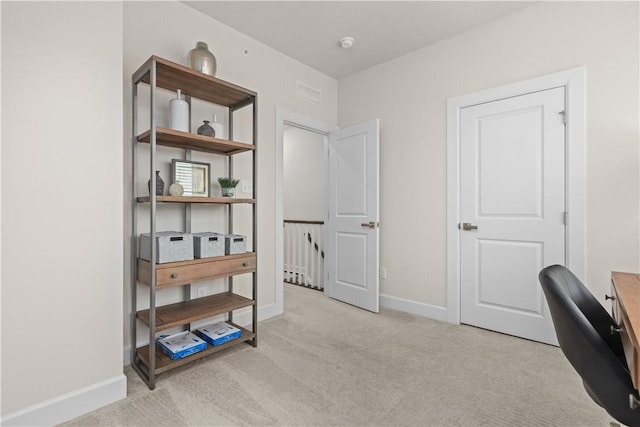 carpeted office space featuring visible vents and baseboards