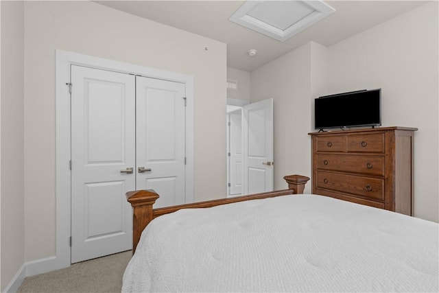 carpeted bedroom with attic access, baseboards, and a closet