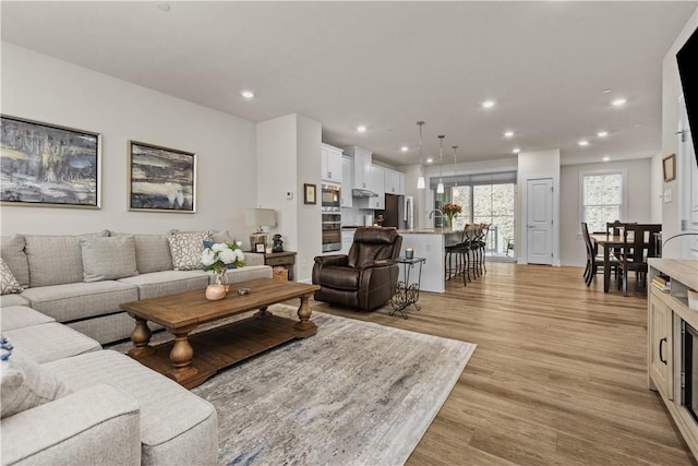 living room with light wood-type flooring and recessed lighting