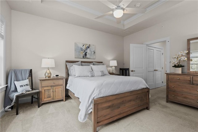 bedroom featuring ceiling fan, a raised ceiling, and light colored carpet