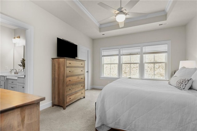 bedroom featuring crown molding, a tray ceiling, baseboards, and light colored carpet