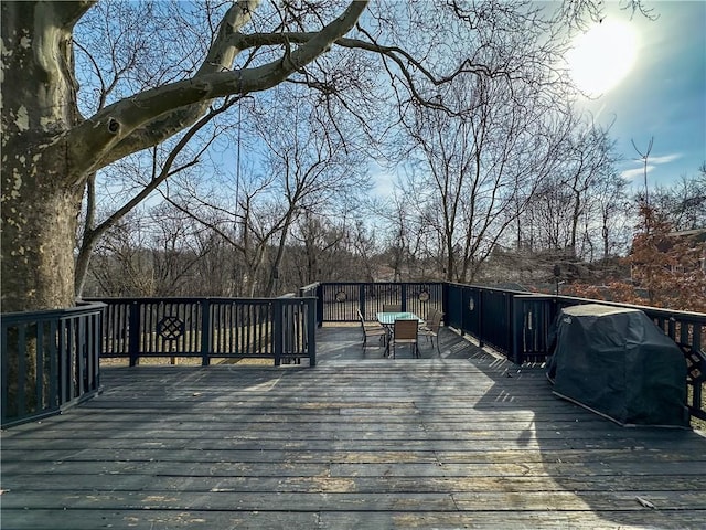 deck with outdoor dining space and area for grilling