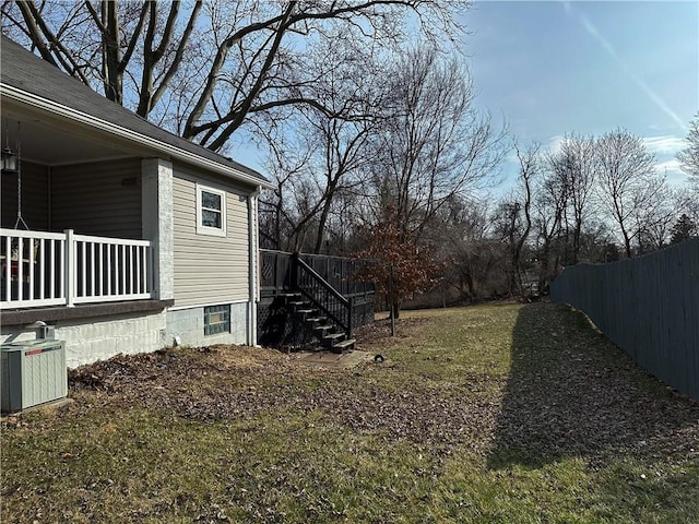 view of yard featuring fence and central AC unit