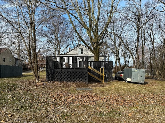 back of house featuring fence, a deck, and stairs