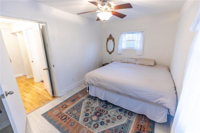 bedroom with light wood-style flooring, baseboards, and a ceiling fan