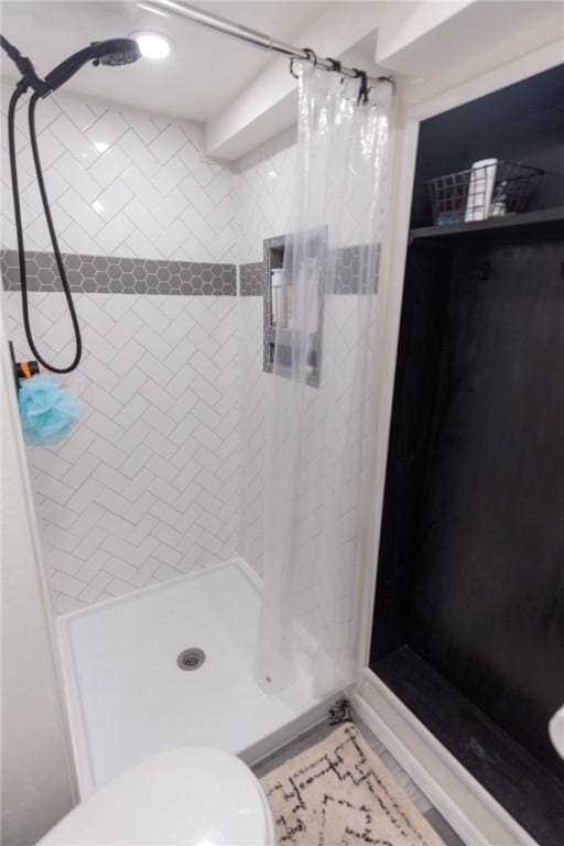 full bathroom with a stall shower and toilet