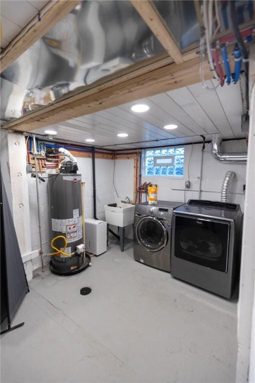 laundry room with washing machine and dryer, laundry area, water heater, and a sink