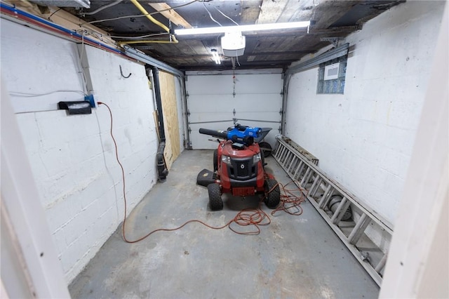 garage with concrete block wall and a garage door opener