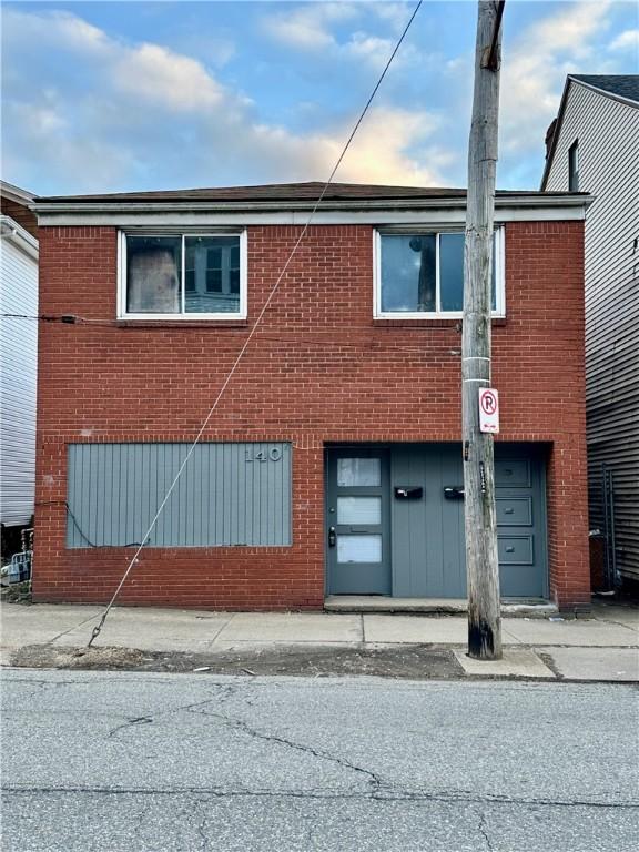 view of front of house featuring a garage and brick siding