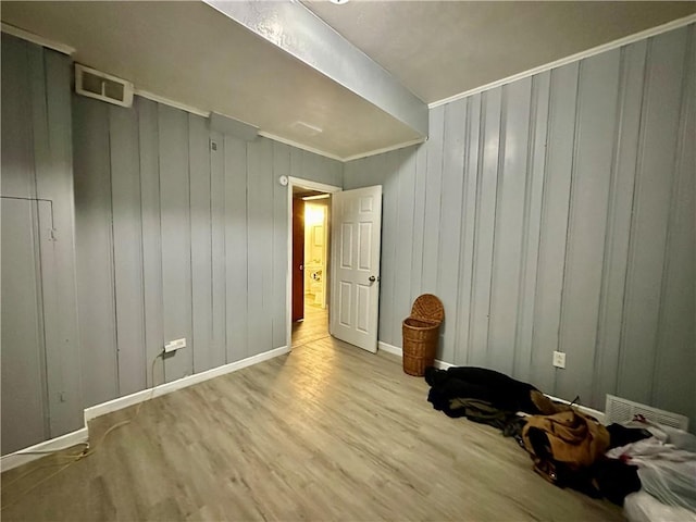 empty room featuring baseboards, visible vents, and wood finished floors