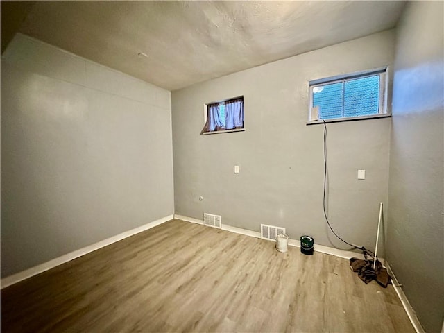 washroom featuring baseboards, visible vents, and wood finished floors