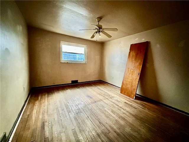 unfurnished room with hardwood / wood-style floors and a ceiling fan