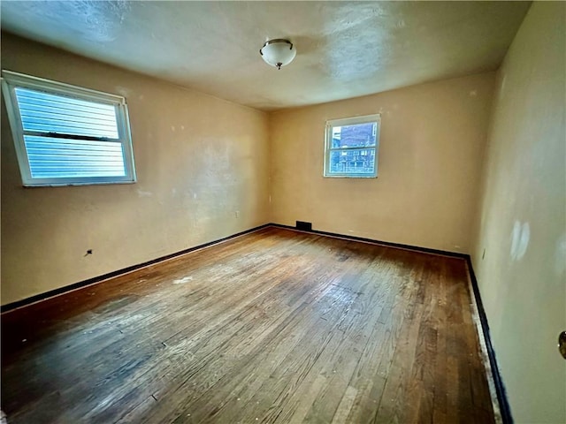 empty room with hardwood / wood-style flooring