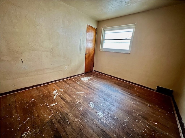 spare room with wood-type flooring and a textured ceiling