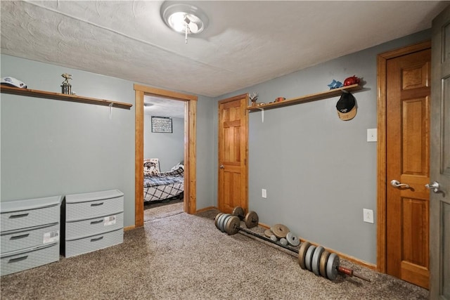 exercise area featuring carpet floors and baseboards