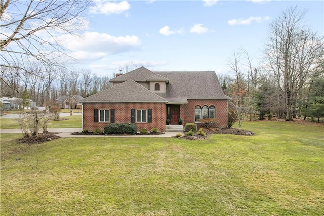 view of front of property featuring a shingled roof, brick siding, a chimney, and a front lawn