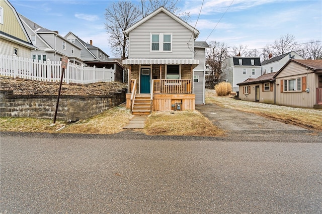 bungalow-style home with a residential view and fence