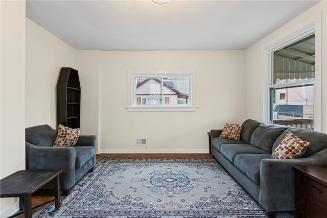 living area featuring wood finished floors, visible vents, and baseboards