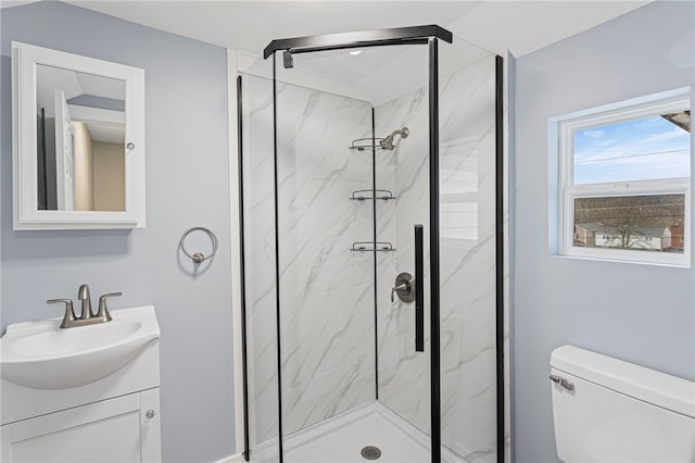 full bath featuring toilet, vanity, and a marble finish shower