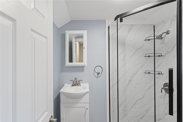 bathroom with lofted ceiling, vanity, and a marble finish shower