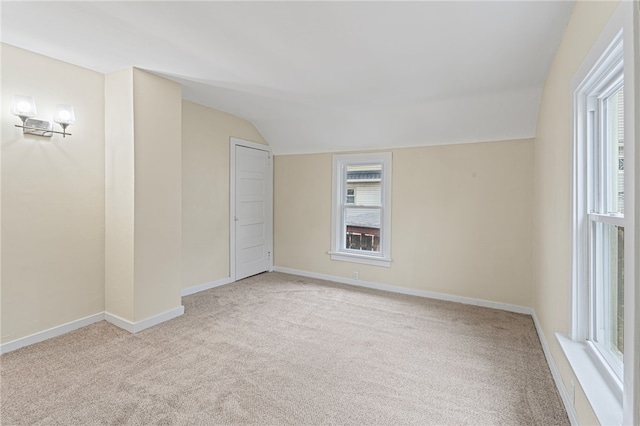 spare room with lofted ceiling, carpet, and baseboards