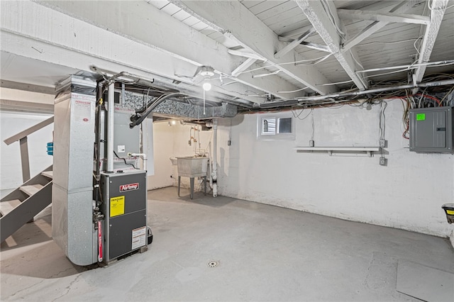 basement with a sink, electric panel, and heating unit